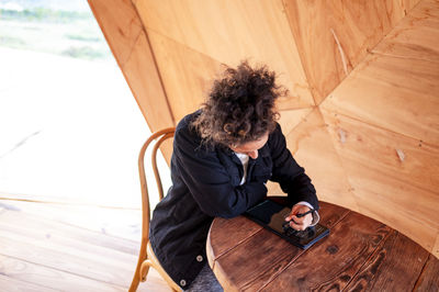 Side view of woman sitting on hammock