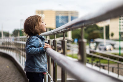 Side view of woman standing on bridge