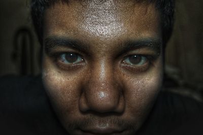 Close-up portrait of man on black background