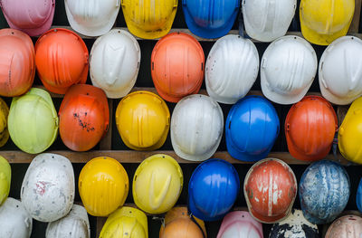 Full frame shot of colorful helmets hanging on rack