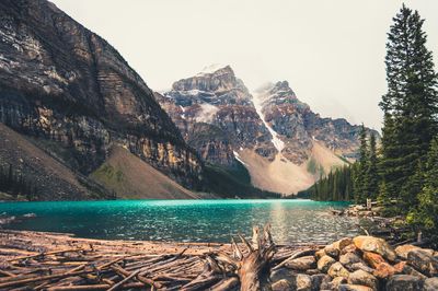 Scenic view of river and rocky mountains against clear sky