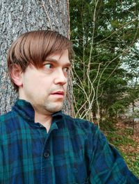 Portrait of young man looking away in forest