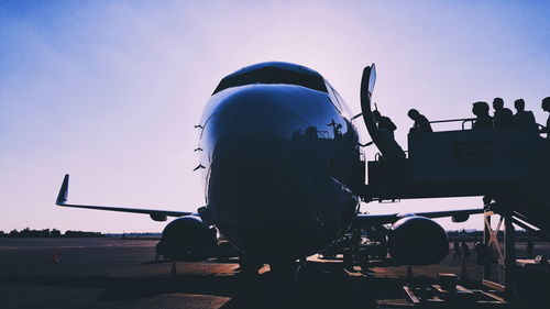 Airplane on airport runway against sky