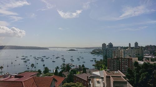 High angle view of townscape by sea against sky