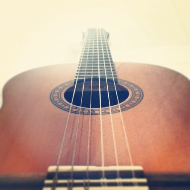 music, indoors, musical instrument, guitar, musical instrument string, musical equipment, arts culture and entertainment, acoustic guitar, single object, close-up, modern, low angle view, string instrument, selective focus, still life, technology, communication, no people, part of, tall - high