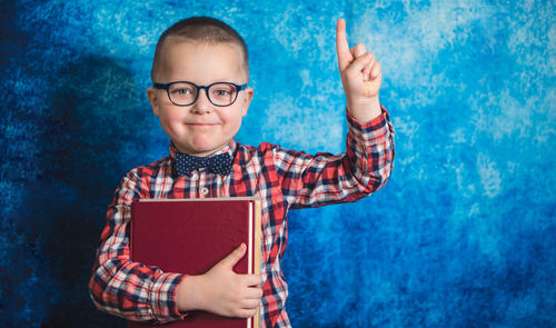 Portrait of smiling boy holding camera