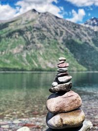 Stack of stones on rock by lake