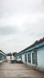 Buildings by road against sky in city