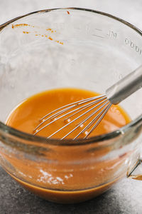 Measuring bowl with marinade and a wire whisk