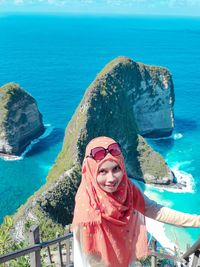 Portrait of smiling woman by sea