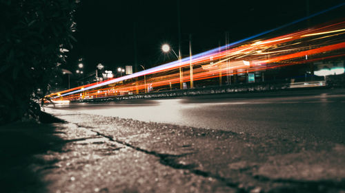 Light trails on road against sky at night