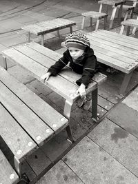 High angle view of girl leaning on wooden table