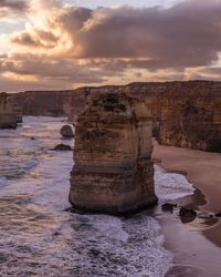 View of rock formation in sea against sky during sunset