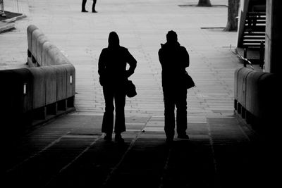 Rear view of silhouette men standing in corridor