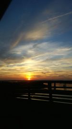 Silhouette road against sky during sunset