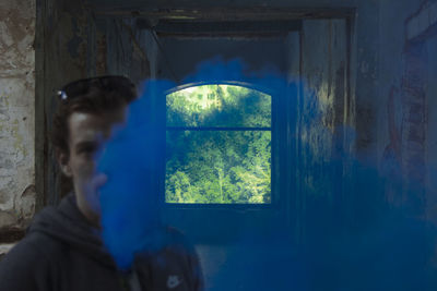 Rear view of man looking through window