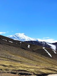 Scenic view of snowcapped mountains against blue sky