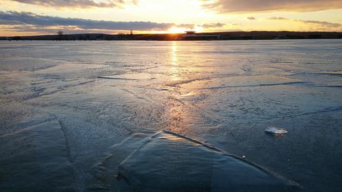 Scenic view of frozen sea against sky during sunset