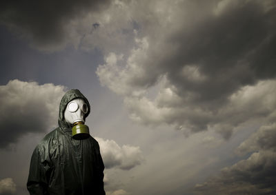 Rear view of man standing against cloudy sky