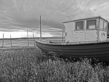 Boat moored at sea shore against sky