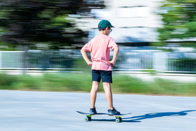 Full length rear view of boy skateboarding
