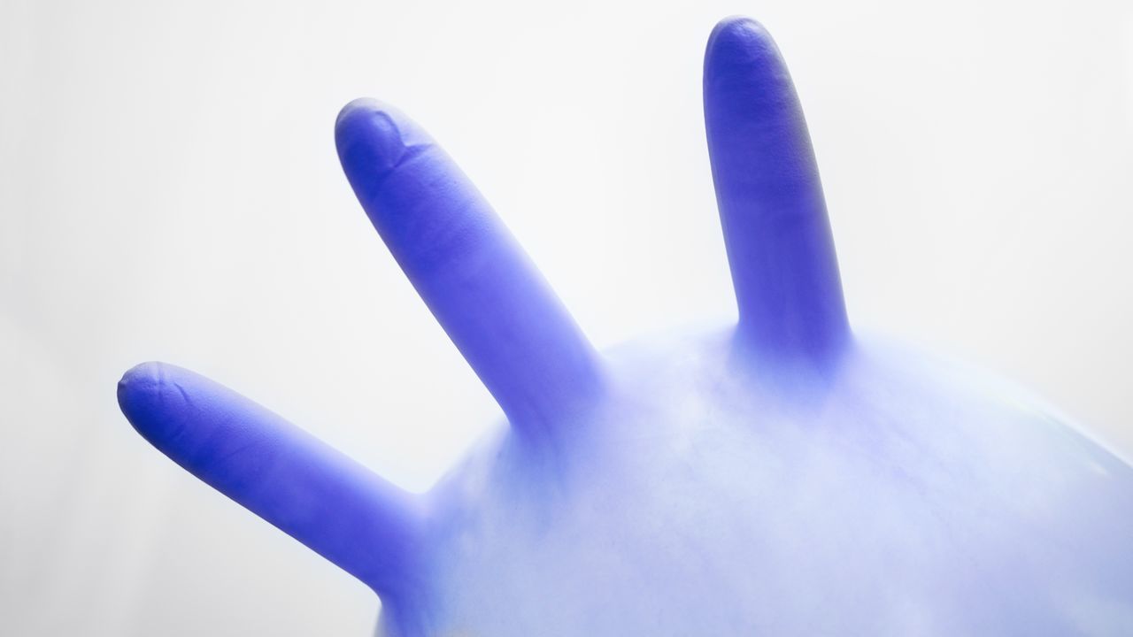 CLOSE-UP OF HUMAN HAND ON BLUE BACKGROUND