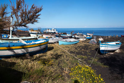 Boats moored on sea against clear sky