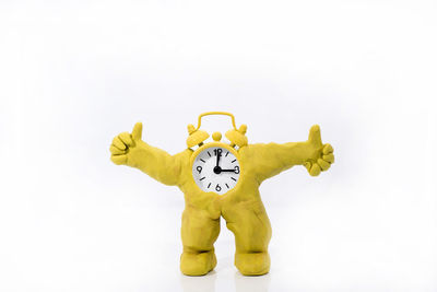 Low angle view of man holding clock against white background