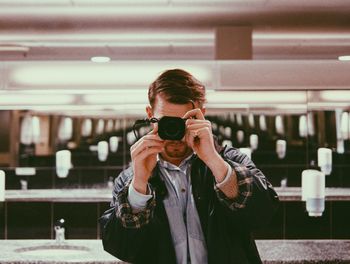 Man photographing in public restroom