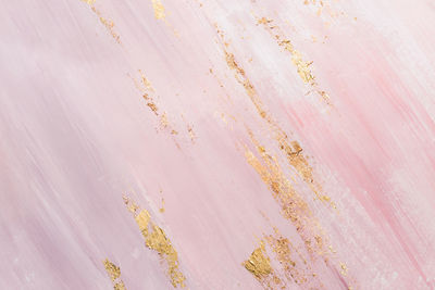 Delicate pink marble background with gold brushstrokes. place for your design.