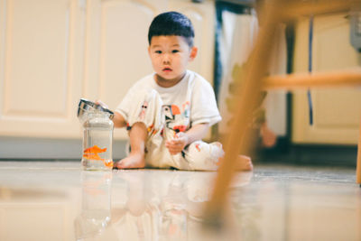 Portrait of cute boy looking away on table