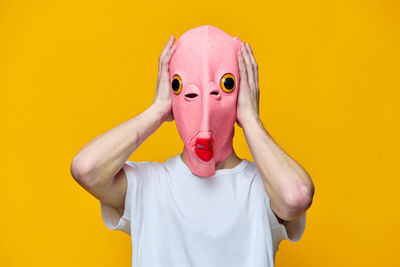 Portrait of woman wearing hat against yellow background