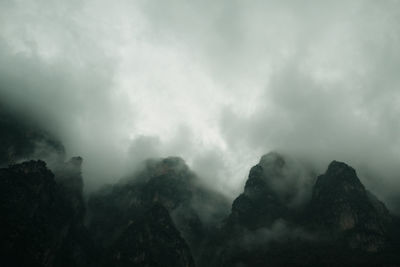 Low angle view of mountain against cloudy sky