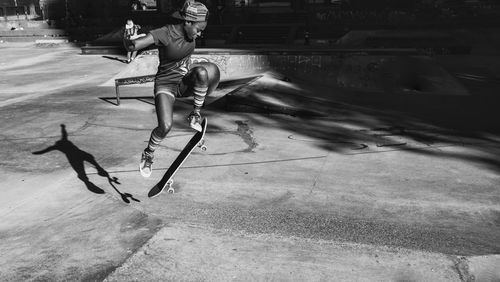 Full length of young woman skateboarding at skateboard park