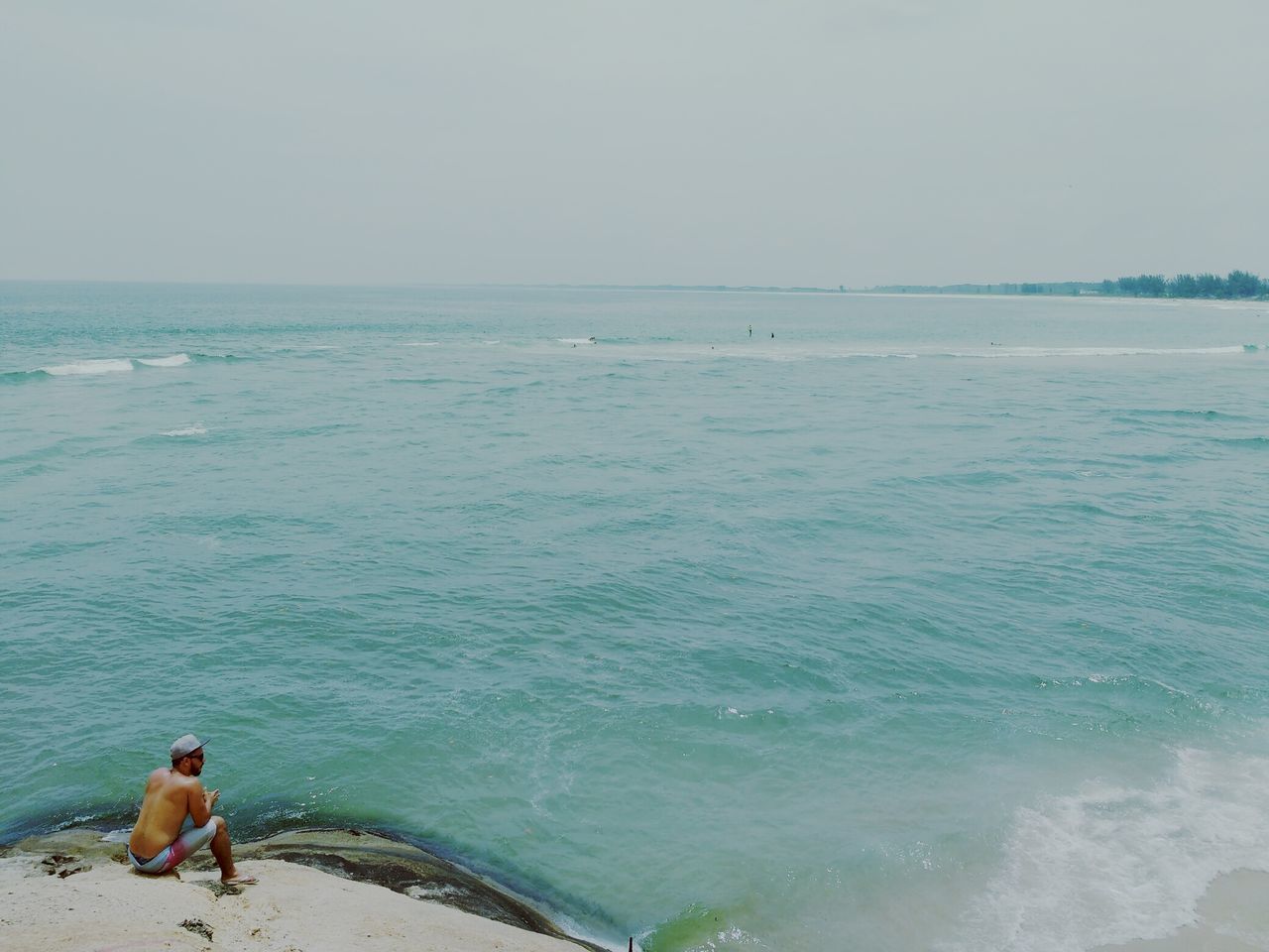 sea, water, lifestyles, leisure activity, men, horizon over water, person, vacations, beauty in nature, scenics, beach, rear view, nature, sitting, copy space, tranquility, sky