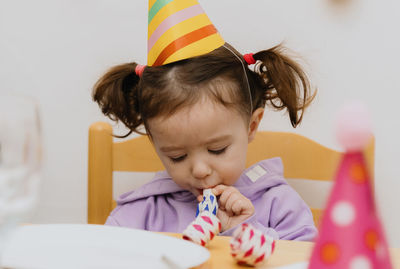 Portrait of a beautiful girl blowing a trumpet at a birthday party.