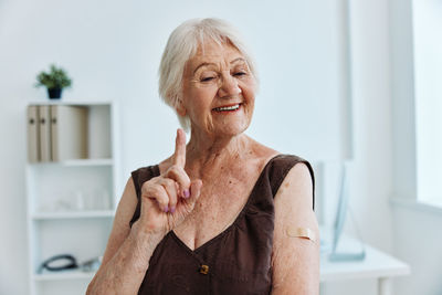 Smiling senior woman gesturing at hospital