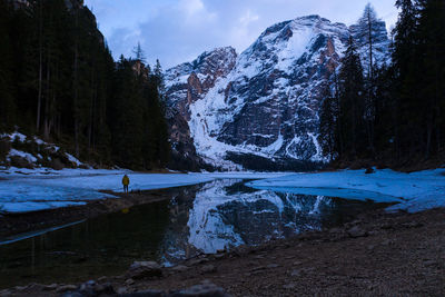 Man standing on land against snowcapped mountains