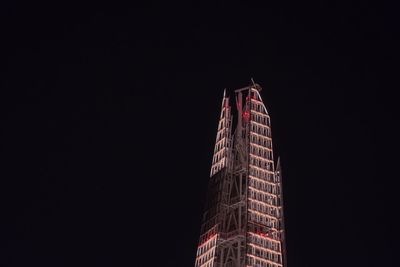 Low angle view of skyscrapers against clear sky at night