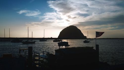 Silhouette of boat in sea during sunset