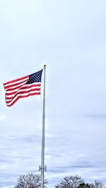 Low angle view of flag flags against sky