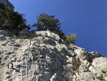 Low angle view of man on rock against sky