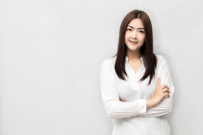 Portrait of smiling young woman against white background