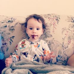 Portrait of cute baby lying on bed