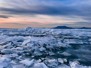 Scenic view of snow covered landscape against sky during sunset