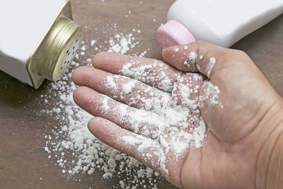 Cropped hand holding talcum powder