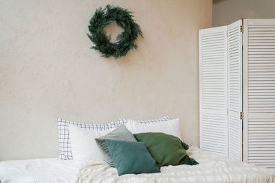 Christmas decor in the bedroom and a wreath on the wall in the scandinavian style interior