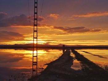 Scenic view of sea against dramatic sky during sunset