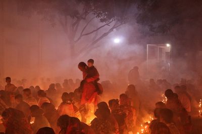 Father walking with son inside croud in rakher upobash at barodi lokhnath brahmachari ashram