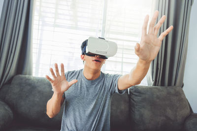 Man wearing virtual reality while sitting at home